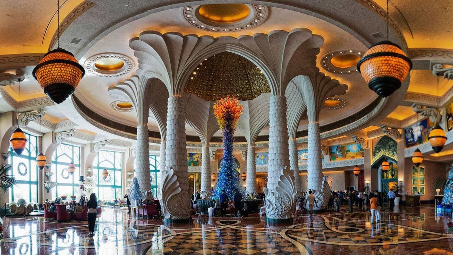 Interior of Atlantis The Palm hotel lobby in Dubai, featuring towering columns, chandeliers, and a spacious luxury design.