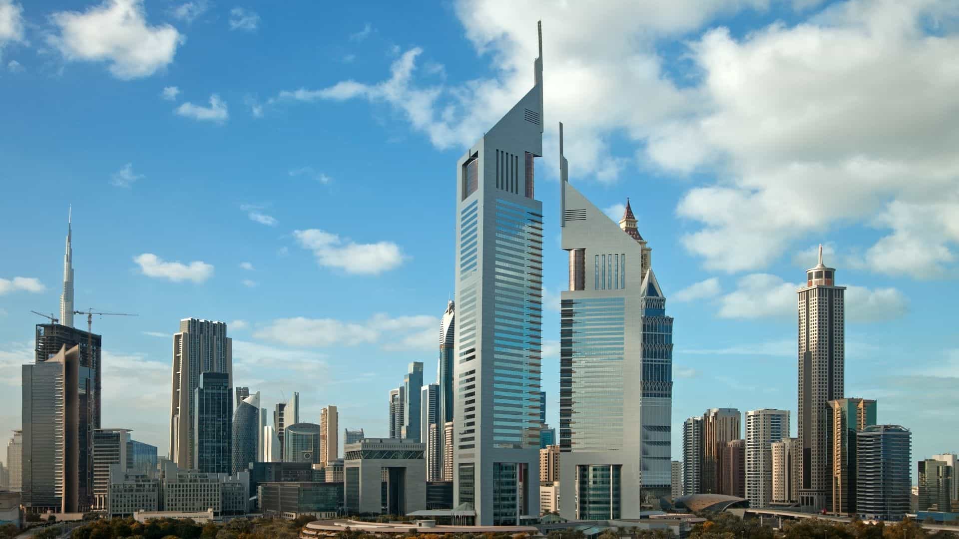 Dubai skyline with modern commercial high-rise buildings under a blue sky, representing GCC real estate and urban development.