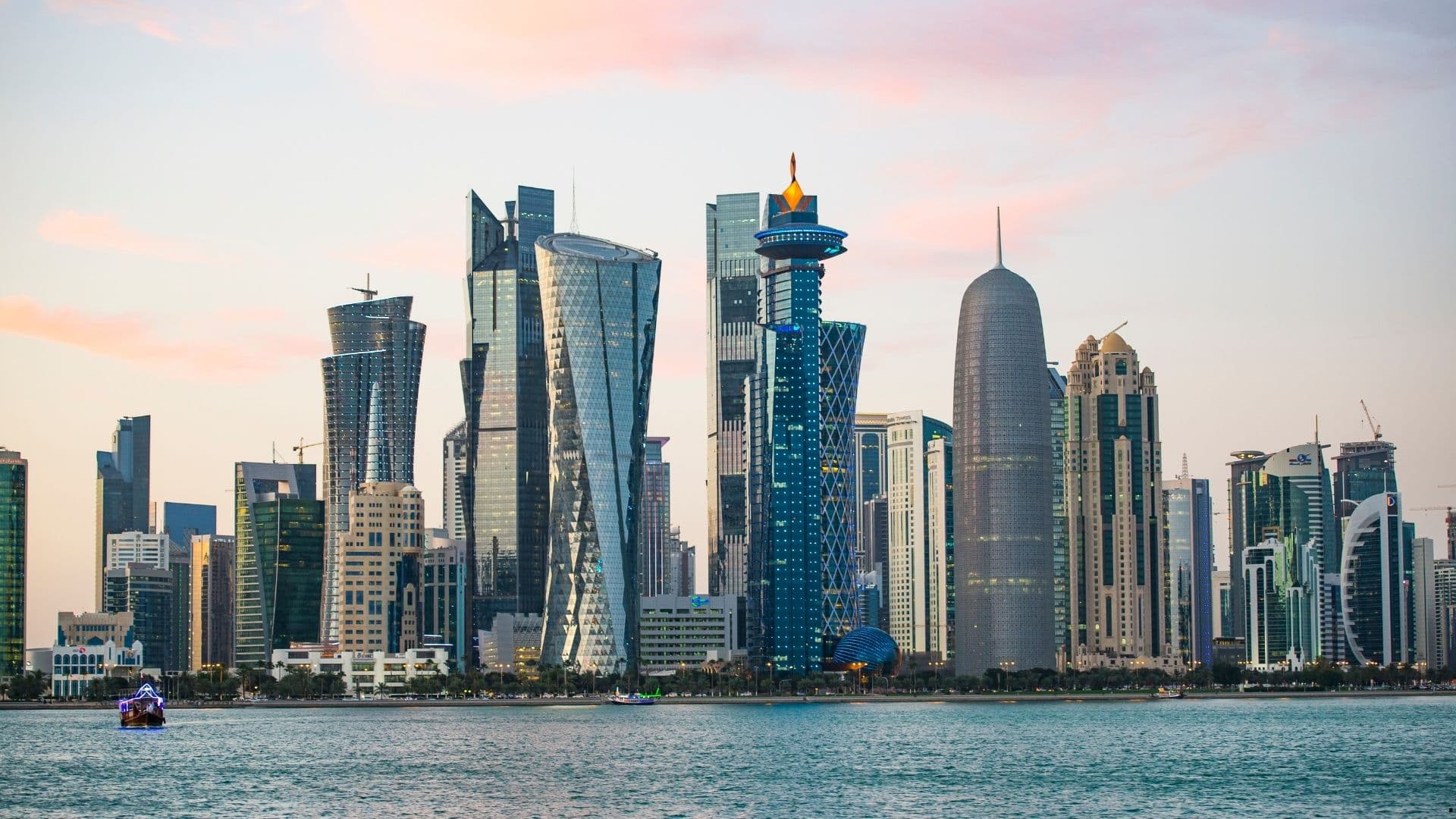 Doha West Bay skyline at dusk across the water, Qatar's financial district.