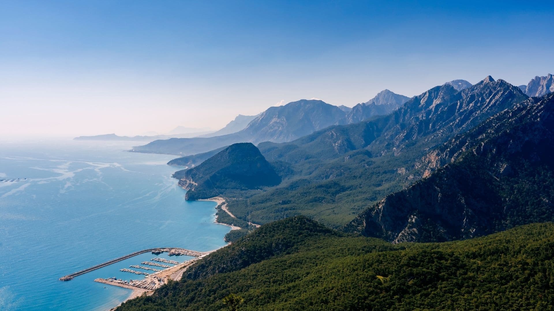 Antalya coastline with the Taurus Mountains rising above a marina and the Mediterranean Sea, Türkiye.